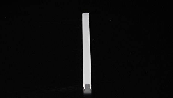 Ein weißes, längliches Objekt in vertikaler Position vor einem schwarzen Hintergrund.