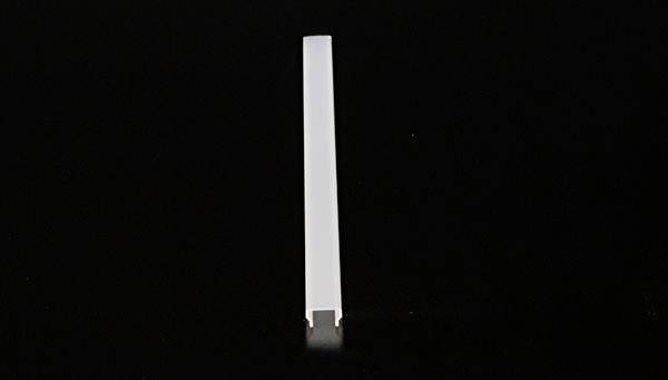 Ein einzelner weißer rechteckiger Stab steht vertikal auf einer schwarzen Oberfläche, zentral im Bild platziert.