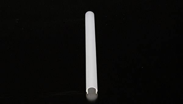 Eine weiße, leere Hülle oder Rohr liegt horizontal auf einem schwarzen Hintergrund.