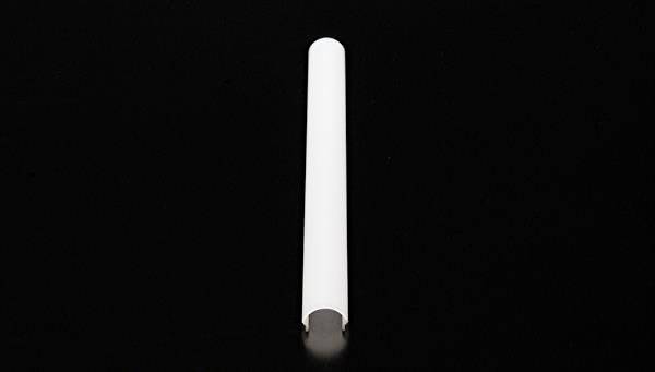 Ein weißer, zylindrischer Plastikgegenstand vor einem schwarzen Hintergrund.