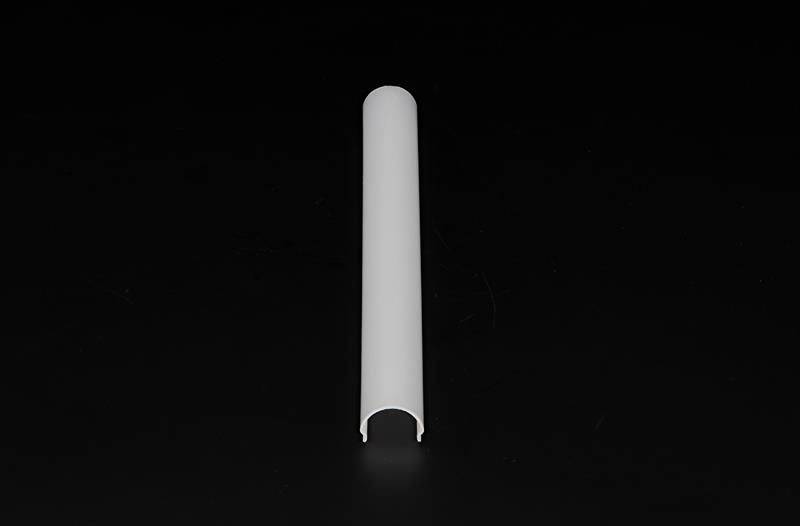 Ein weißes, halbkreisförmiges Kunststoffstück liegt auf schwarzem Hintergrund.