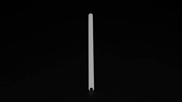 Ein einzelner weißer Strohhalm steht vertikal vor einem schwarzen Hintergrund.