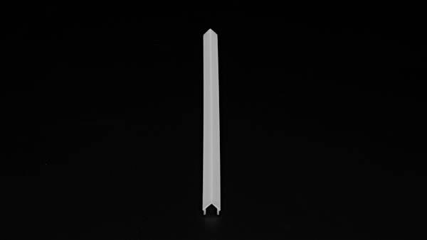 Ein einzelner, weißer, länglicher Plastikstöpsel steht vertikal auf einer schwarzen Oberfläche.