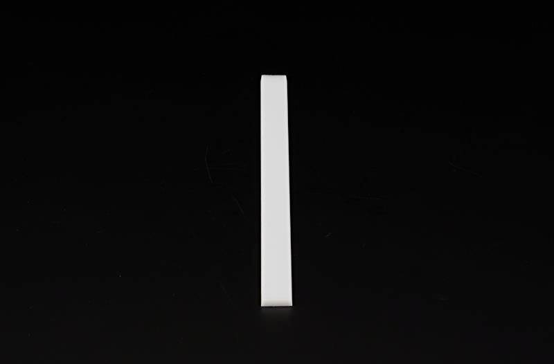 Eine weiße rechteckige Stange steht aufrecht auf einem schwarzen Hintergrund.