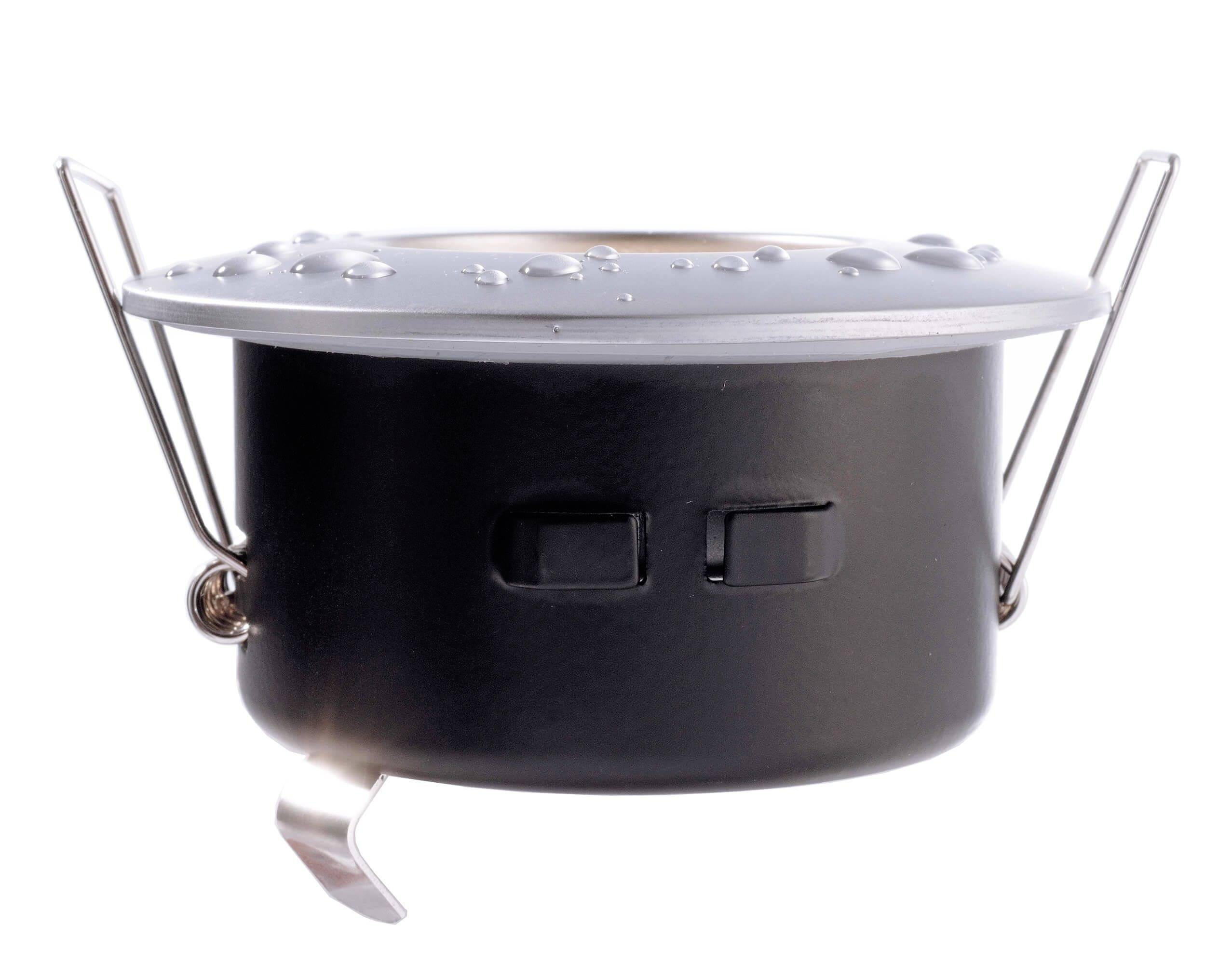Ein schwarzer Topf mit Metallgriffen, bedeckt mit einigen Wassertropfen.