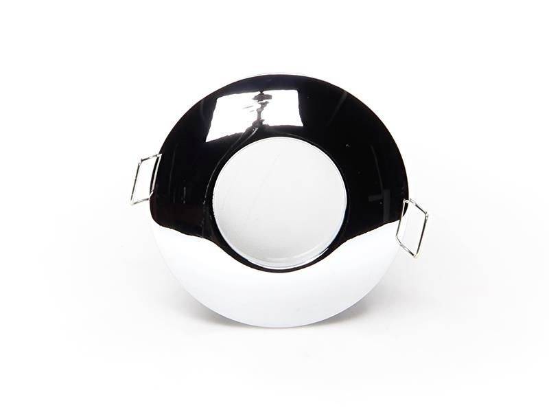 Ein glänzender, runder Spiegel mit zwei quadratischen Haltern an den Seiten. Der Spiegel reflektiert Licht von oben.