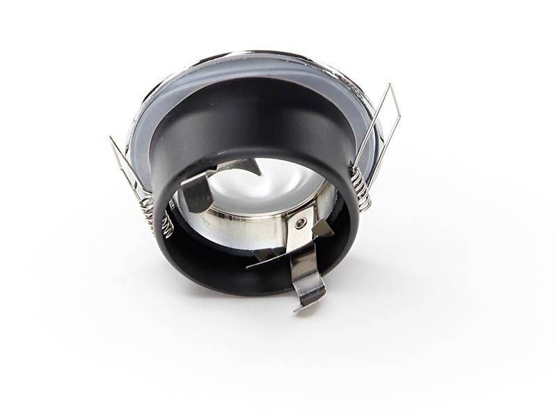 Ein runder Einbaustrahler aus Metall mit Klammern zur Befestigung. Ist für Deckenlichtinstallationen geeignet.