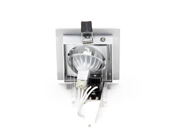 Ein quadratischer Einbauspot mit silbernem Rahmen, zeigt ein sichtbares Leuchtmittel und angeschlossene Kabel. Eignet sich für Deckenmontage.