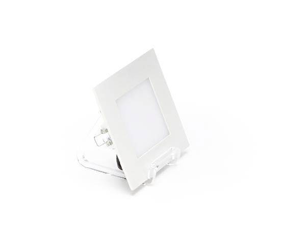 Ein quadratischer, weißer LED-Deckeneinbauspot aus Kunststoff, leicht schräg platziert, mit sichtbaren Anschlusskabeln.