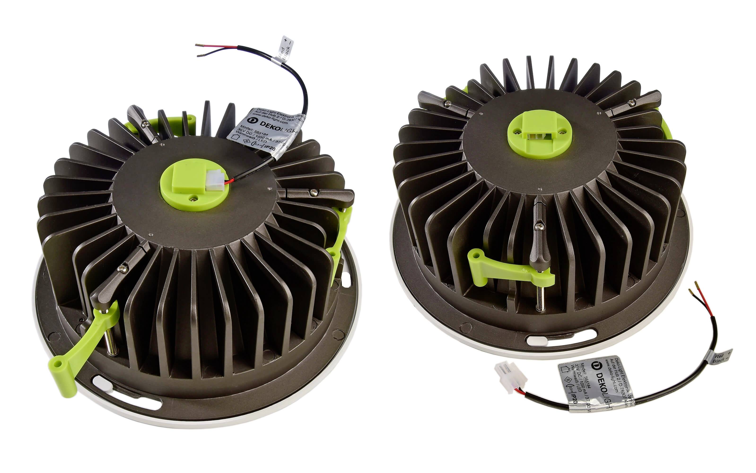 Zwei runde, metallische Kühlkörper mit grünen Kunststoffelementen und Kabel, die für die Wärmeableitung elektronischer Geräte verwendet werden.