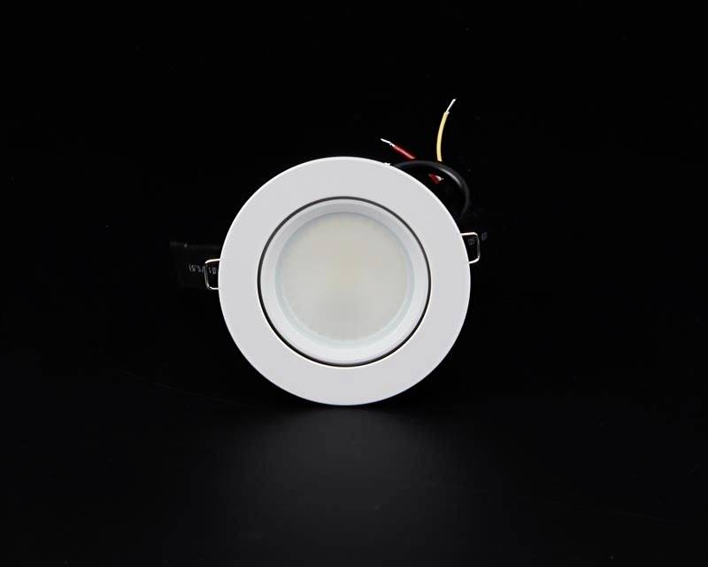 Ein weißer runder LED-Deckeneinbauspot mit Kabeln, gezeigt vor einem schwarzen Hintergrund.