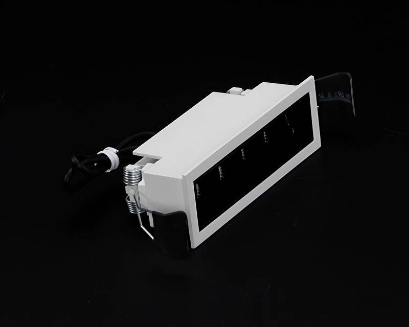 Ein rechteckiger, schwarzer Schalttafel-Kasten mit Kabelanschluss liegt auf einem dunklen Hintergrund.