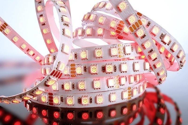 LED-Lichtbänder in Rot, aufgerollt und leuchtend, vor einem weißen Hintergrund. Geeignet für dekorative Beleuchtung.