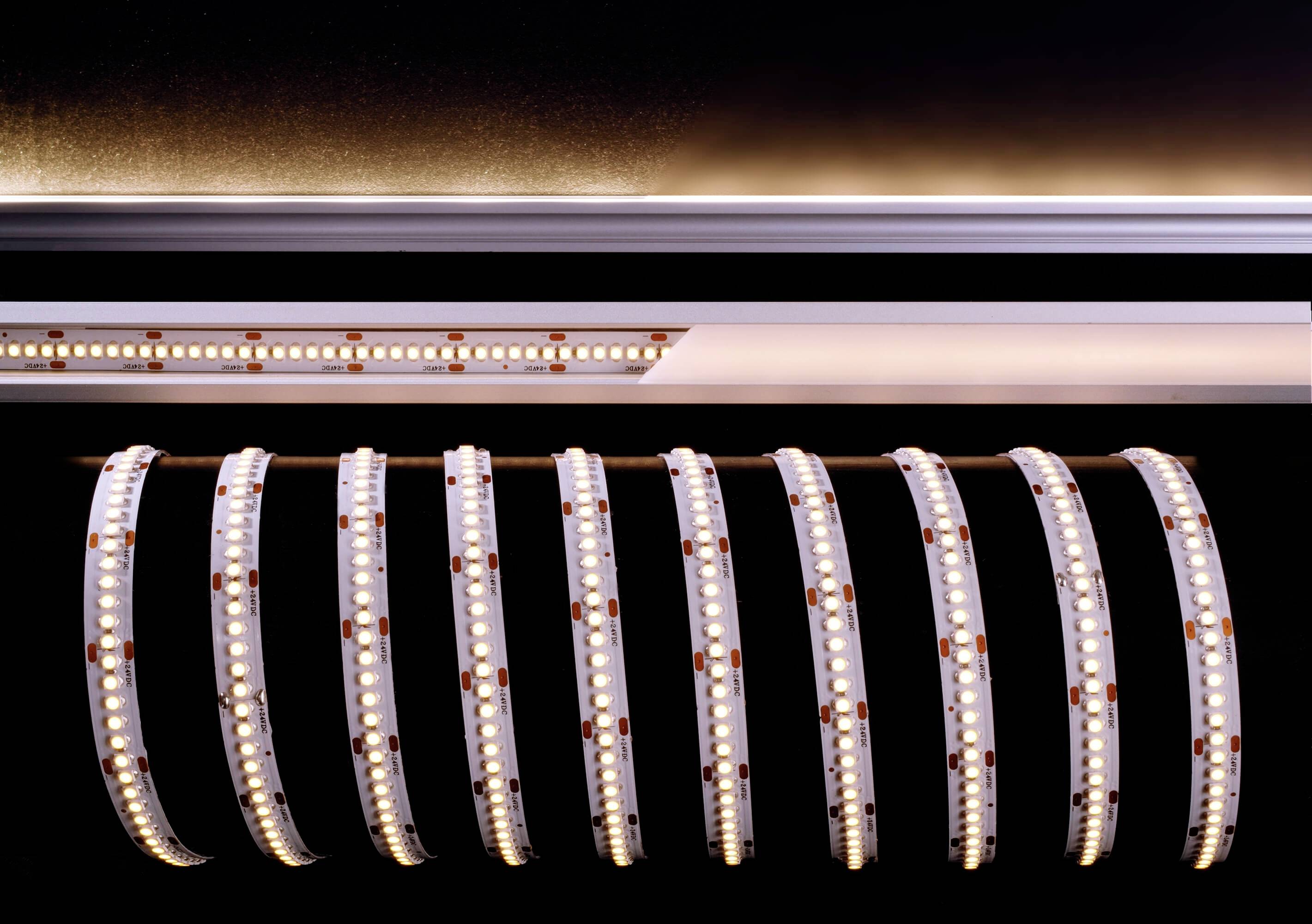 Eine gerollte LED-Lichtleiste mit leuchtenden Dioden in einem dunklen Raum. Die Leiste zeigt Details der Elektronik und Struktur.