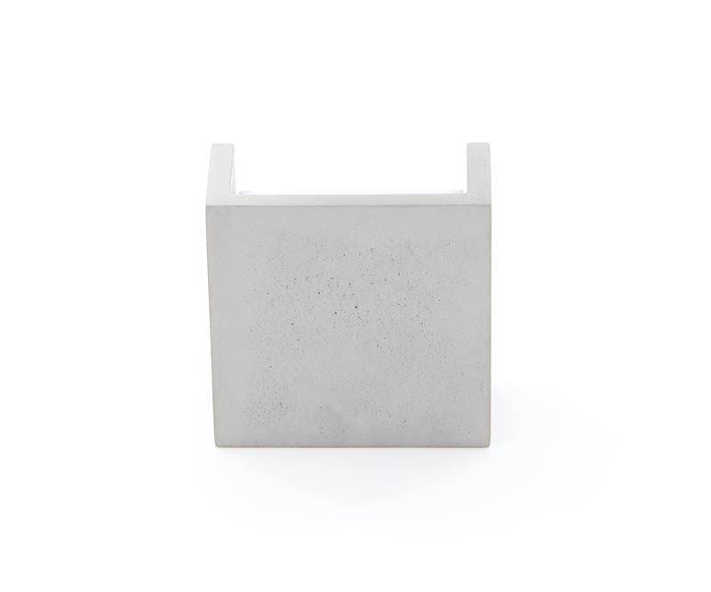 Ein minimalistisches Design-Objekt aus Beton in würfelförmiger Struktur, möglicherweise ein Dekorationsstück oder Möbelstück.