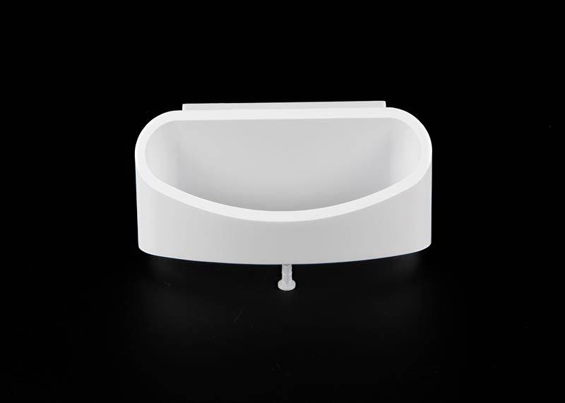 Ein weißes, modernes Wandwaschbecken vor schwarzem Hintergrund, mit glatter, gebogener Form und kleinem Abfluss in der Mitte.