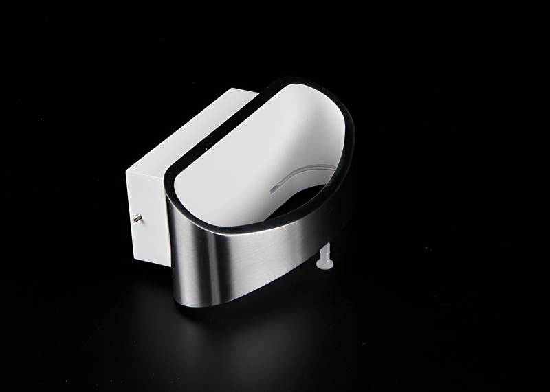 Ein weiß-schwarzes Wandregal in ovaler Form mit einem Edelstahlrahmen. Das Regal hat eine versteckte Wandmontage.