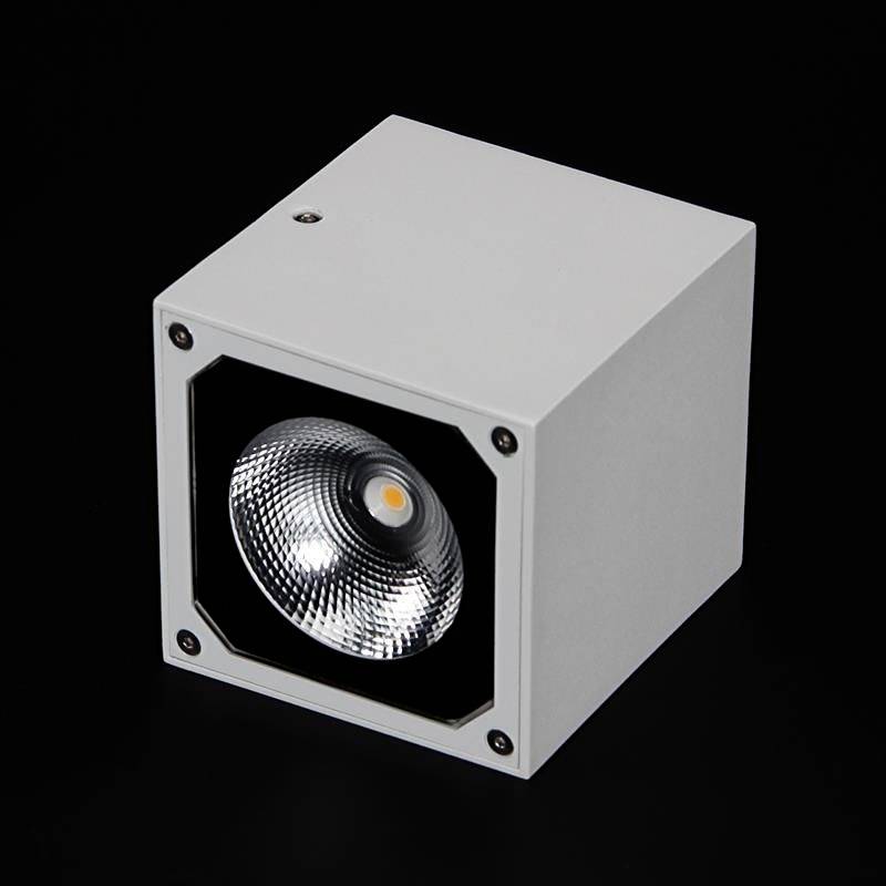 Weiße, würfelförmige LED-Lampe mit eingebautem Reflektor und schwarzem Hintergrund.