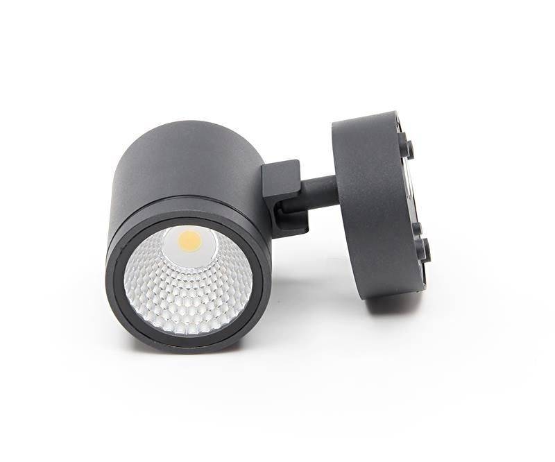 Ein schwarzer LED-Strahler mit rundem Gehäuse und Wabenstruktur-Reflektor liegt auf einer weißen Oberfläche. Geeignet für Schienenmontage.