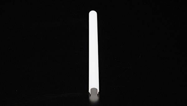 Ein langer, weißer zylindrischer Gegenstand liegt horizontal auf einem schwarzen Hintergrund.