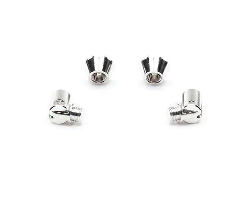 Vier silberne Metallschrauben liegen auf weißem Hintergrund, zwei stehen und zwei liegen seitlich. Sie sind zylinderförmig und reflektieren Licht.