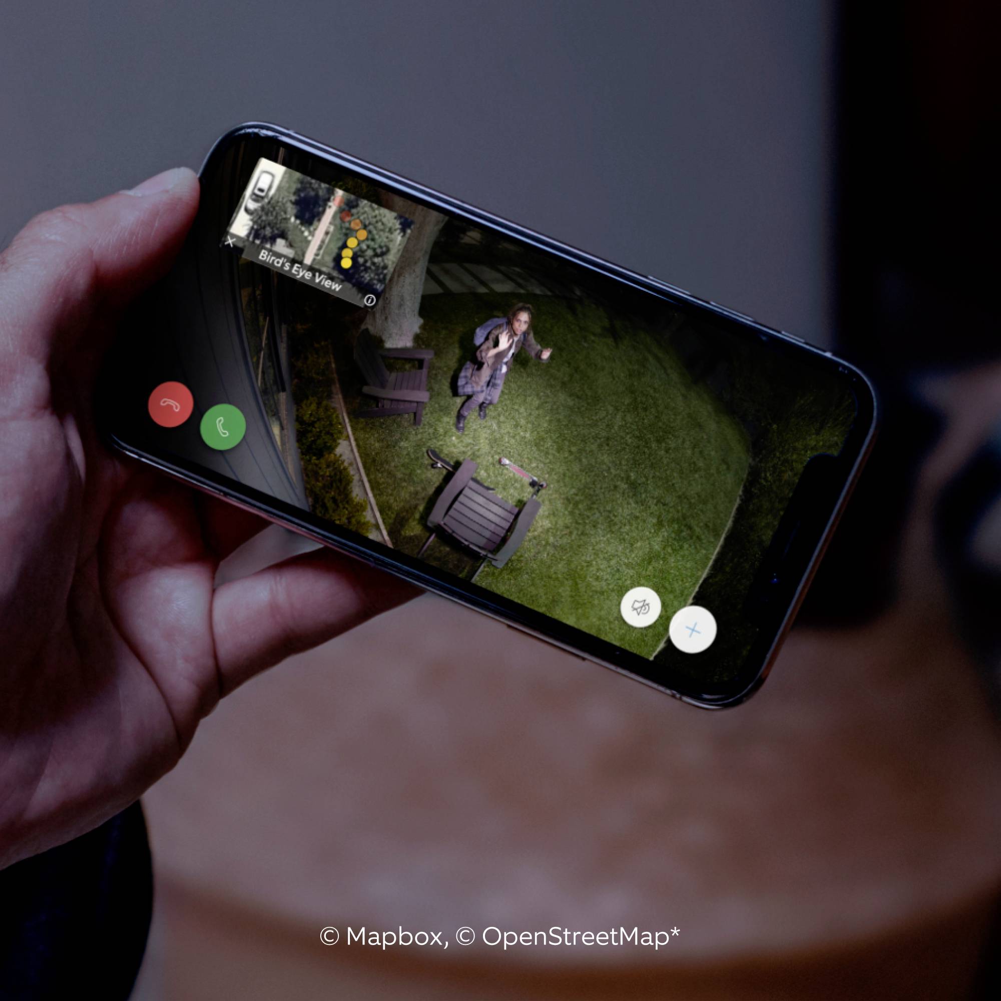 Ein Smartphone zeigt eine Kartenansicht mit einem Pin. Auf der Karte wird eine Person im Freien angezeigt, was auf eine Ortung hinweist.