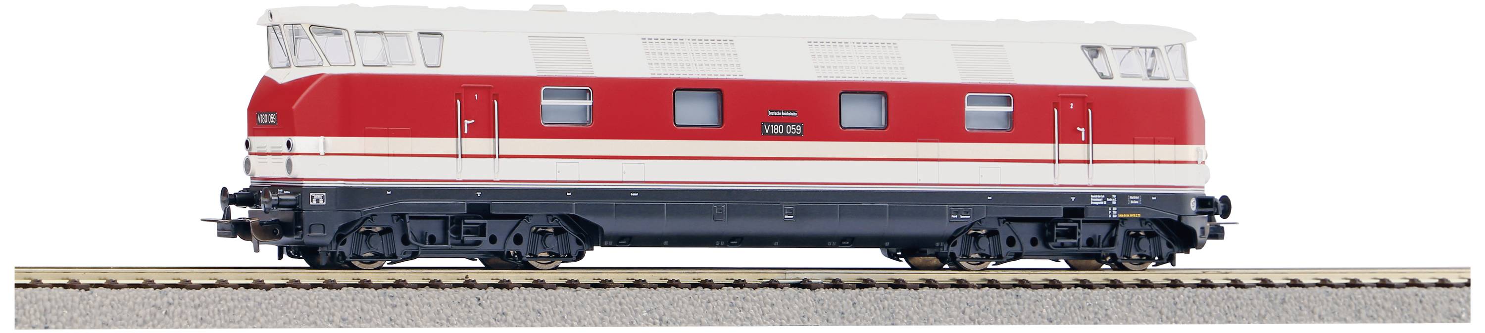 Eine rote Modelllokomotive mit weißen Streifen auf einem Gleisabschnitt.