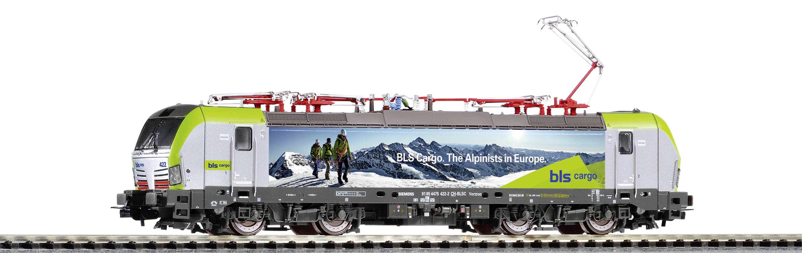 Ein Modellzug mit einer Werbegrafik für 'bls cargo - The Alps in Europe'. Im Hintergrund sind schneebedeckte Alpen zu sehen.
