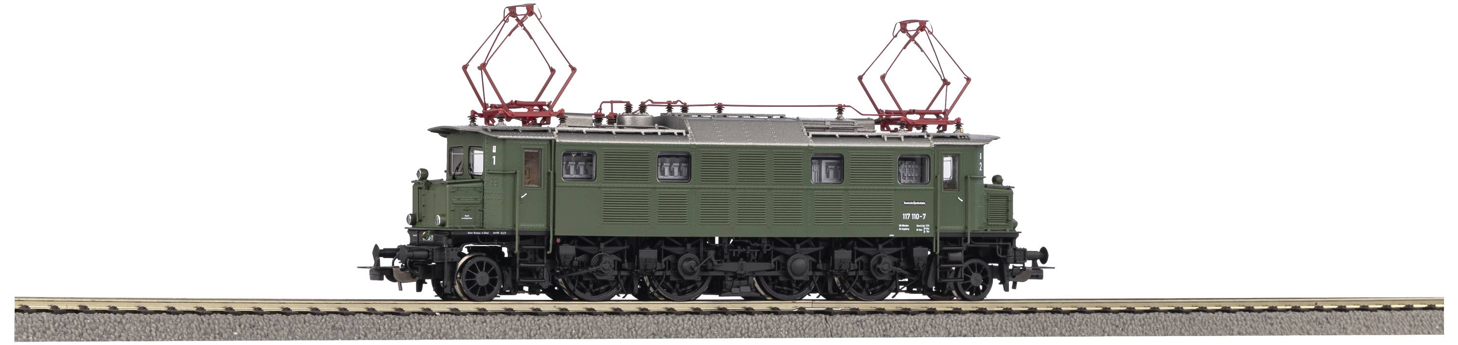 Historische grüne Lokomotive auf Bahngleis, seitliche Ansicht. Elektrische Oberleitung und schwarze Räder erkennbar.