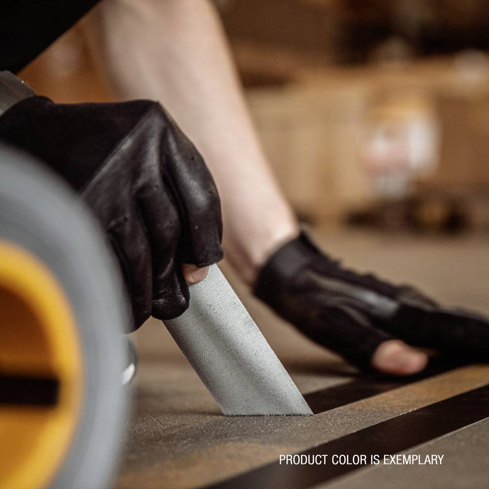 Person schneidet sorgfältig Material mit einem Teppichmesser; Fokus auf Händen mit schwarzen Handschuhen. Text in Bild: 'PRODUCT COLOR IS EXEMPLARY'.
