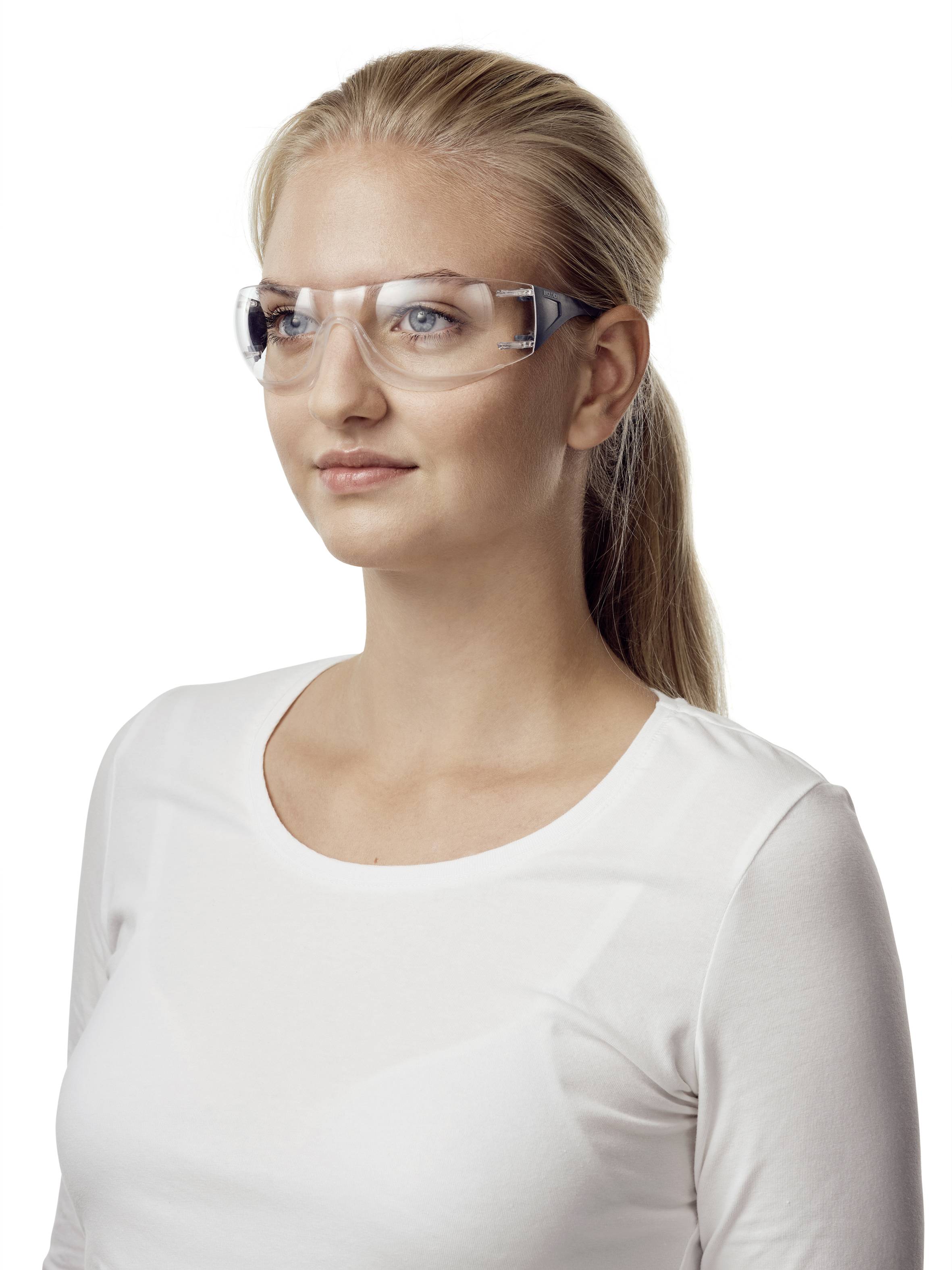 Eine Frau mit langen blonden Haaren trägt eine Schutzbrille und ein weißes Oberteil. Sie blickt leicht zur Seite.