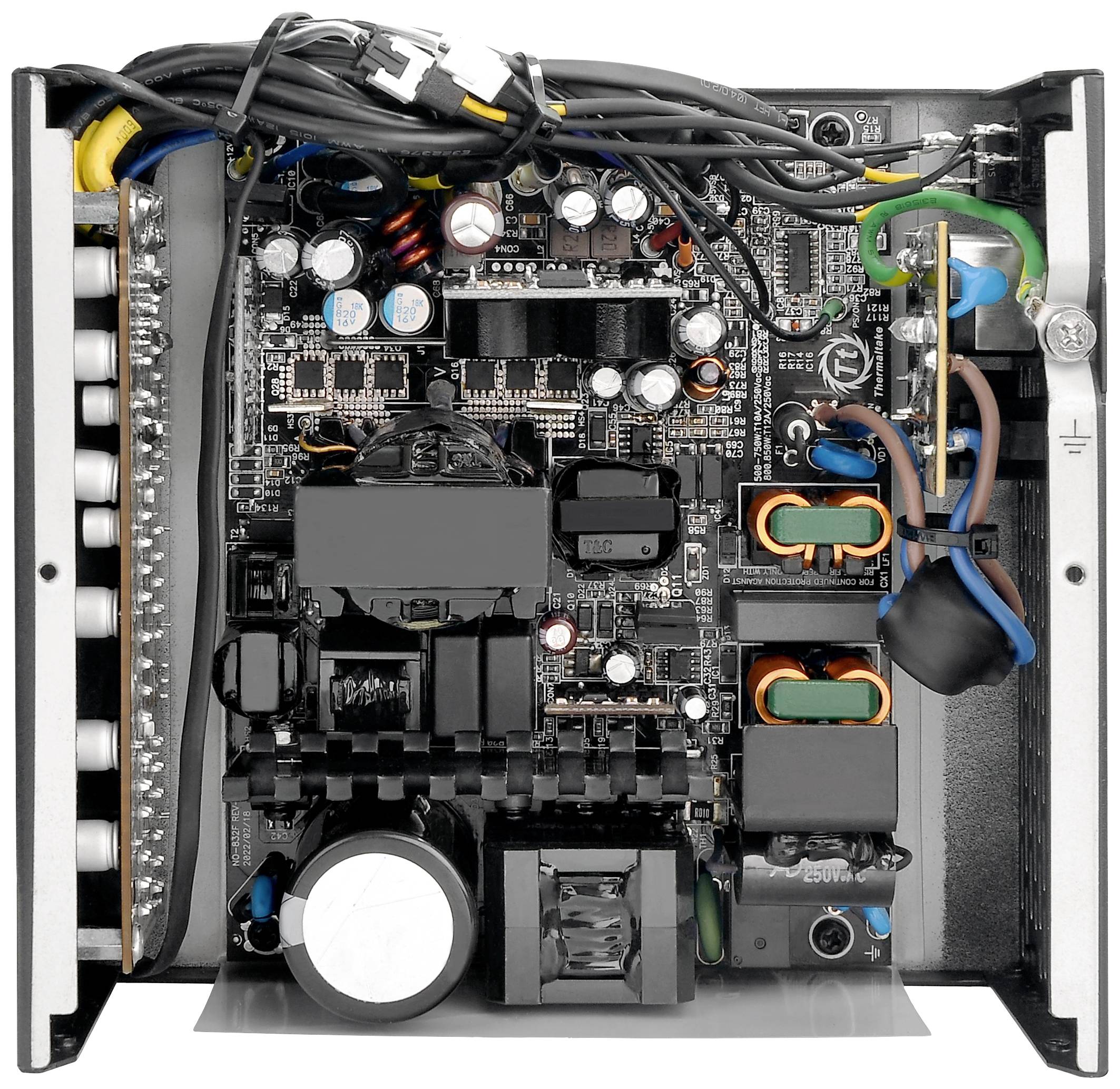 Offenes Computernetzteil mit sichtbaren elektronischen Bauteilen und Verkabelung, zeigt interne Struktur und Anordnung der Komponenten.