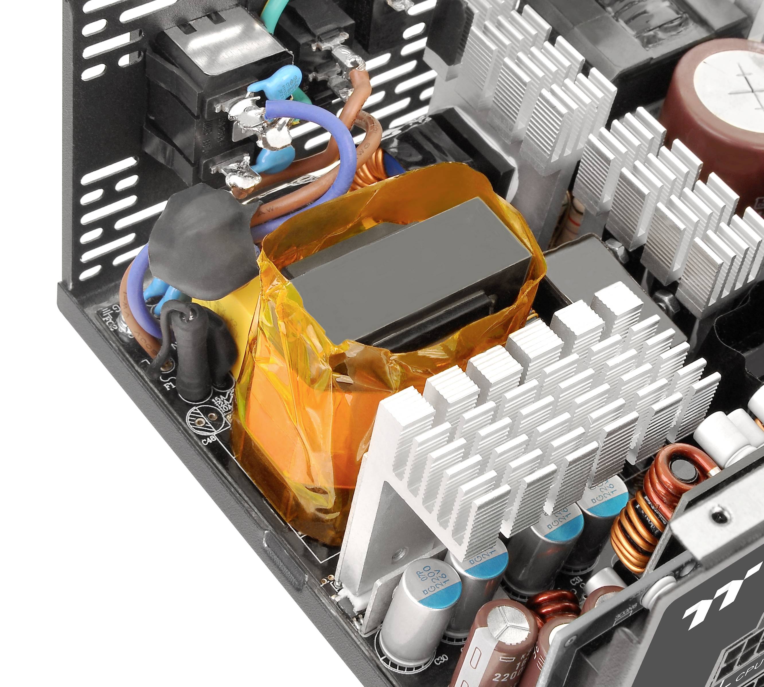 Nahaufnahme eines Computer-Netzteils mit sichtbaren Komponenten wie Kondensatoren, Kühlkörpern und Kabelanschlüssen.