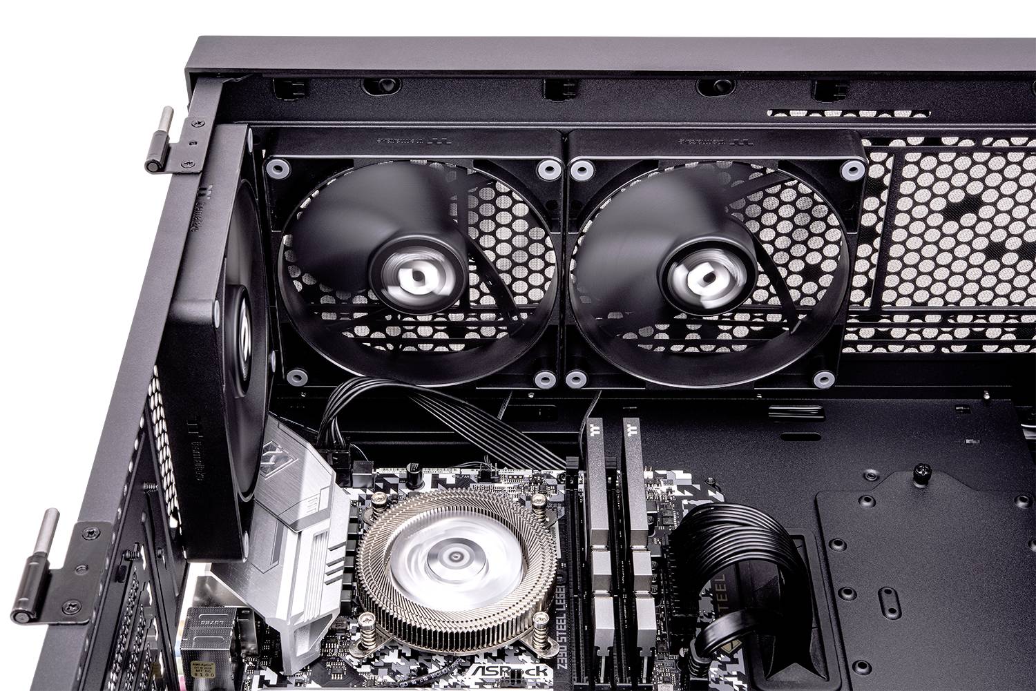 Das Bild zeigt das Innere eines Computergehäuses mit installierten Lüftern, einem Kühler und sichtbaren Kabeln auf einem Mainboard.