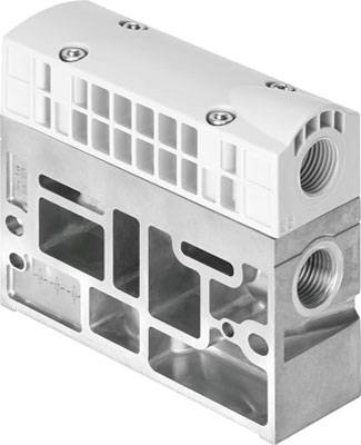 Ein silbernes und weißes Maschinenteil, vermutlich ein Ventilblock, mit mehreren Öffnungen und Gewinden für Verbindungen oder Schläuche.