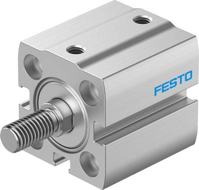 Ein pneumatischer Zylinderblock aus Metall mit abgerundeten Ecken, der ein zentrales Gewinde hat. Ein blaues Logo 'FESTO' ist sichtbar.