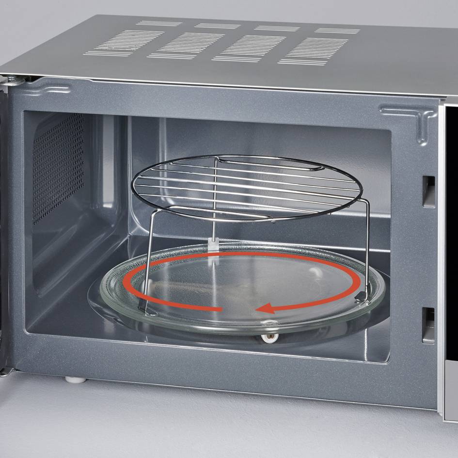Geöffnete Mikrowelle mit Drehteller und Grillrost im Inneren, bereit zur Nutzung. Rückwand aus Metall mit Belüftungsschlitzen.