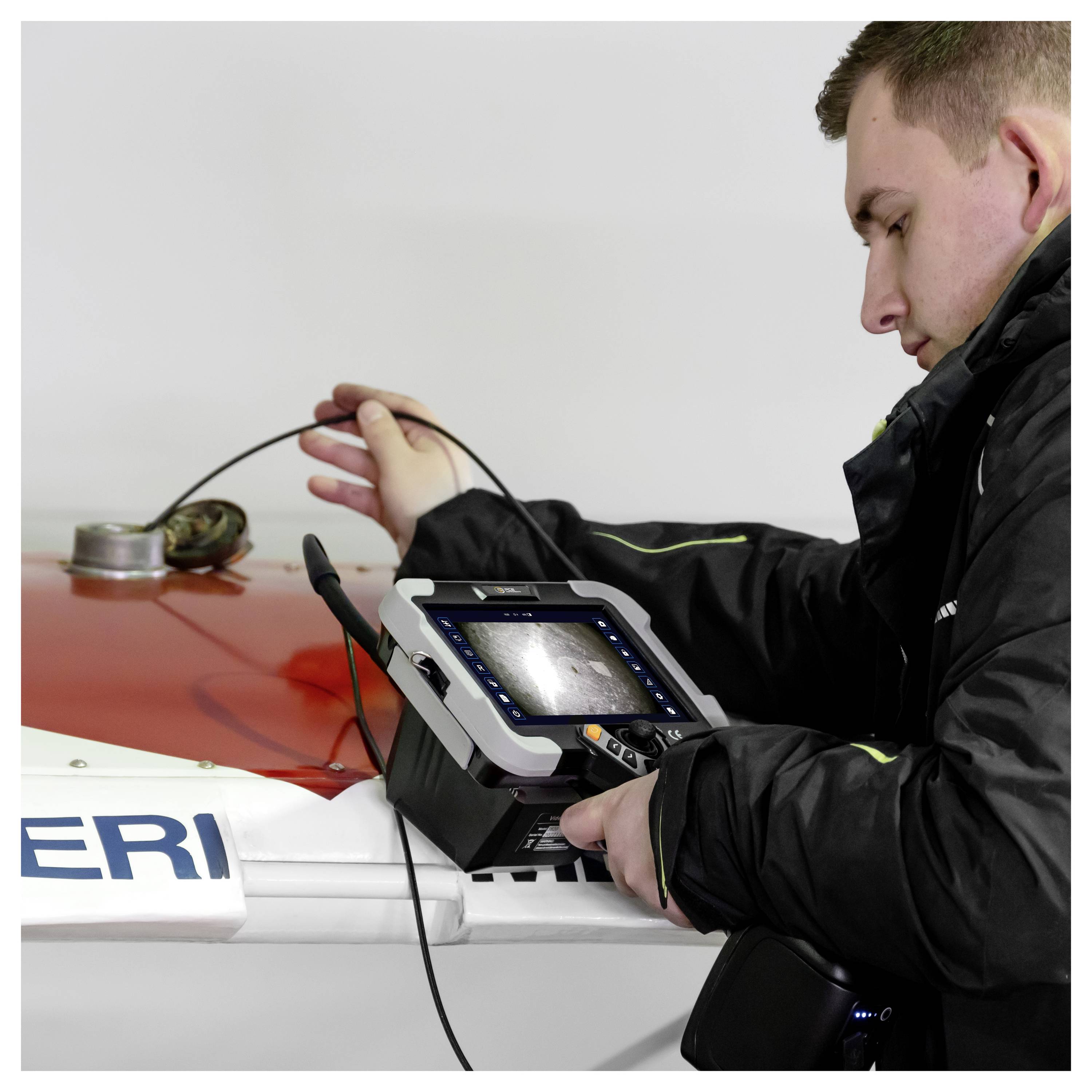 Techniker inspiziert ein Fahrzeug mit einer tragbaren Diagnosekamera auf der Motorhaube des Autos