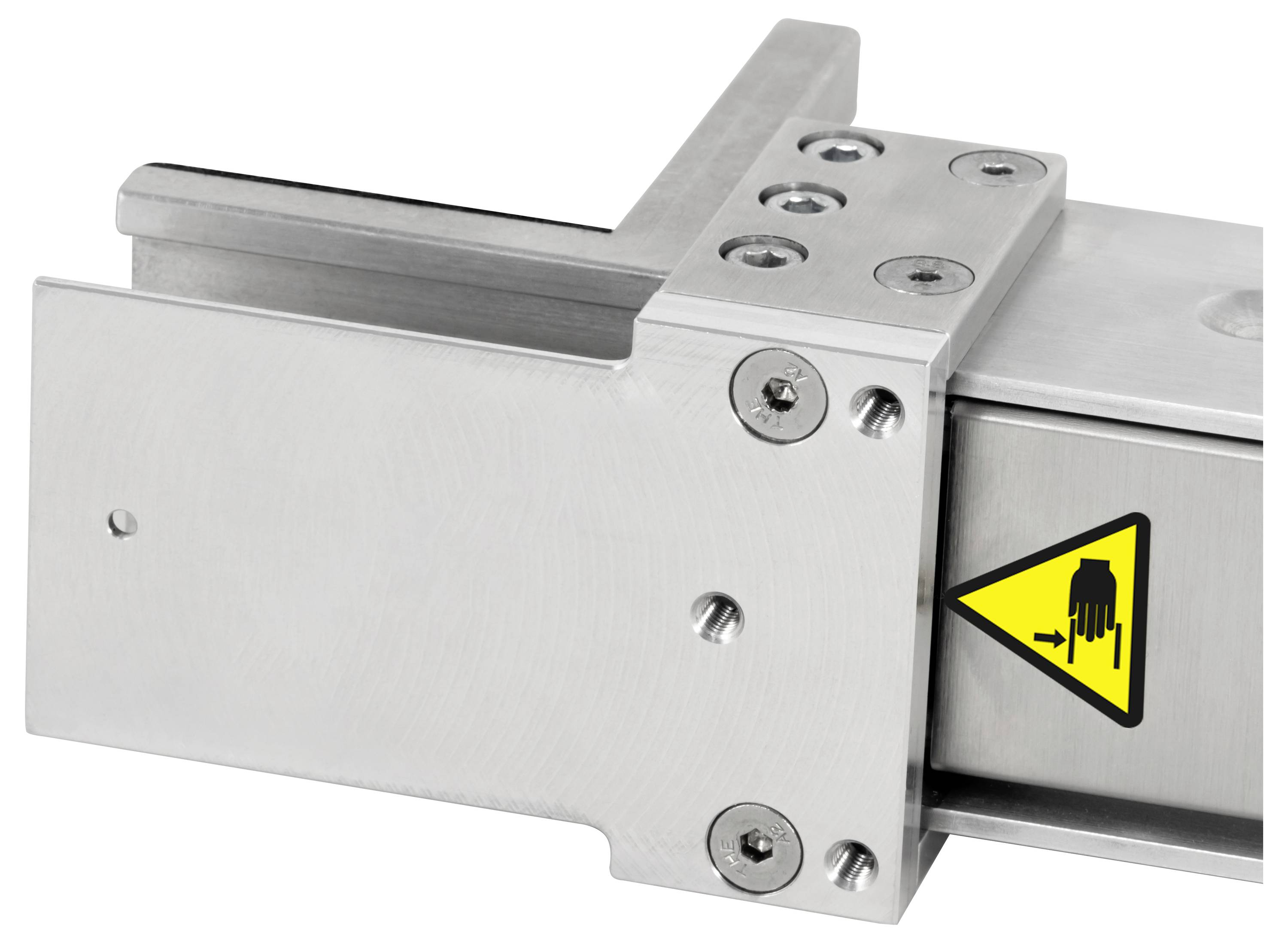 Nahaufnahme einer Metallschutzvorrichtung oder Förderanlageneinheit mit einem gelben Warnschild, das auf eine Quetschstelle hinweist.