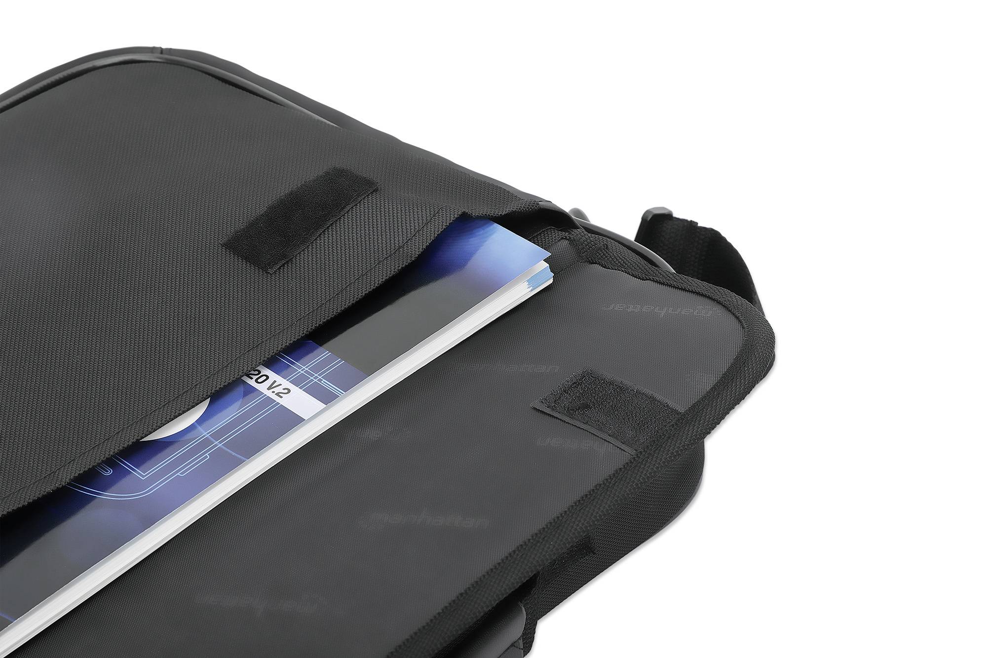 Eine schwarze Tasche, teilweise geöffnet, mit einem blauen Heft oder Buch, das aus der Tasche herausragt.