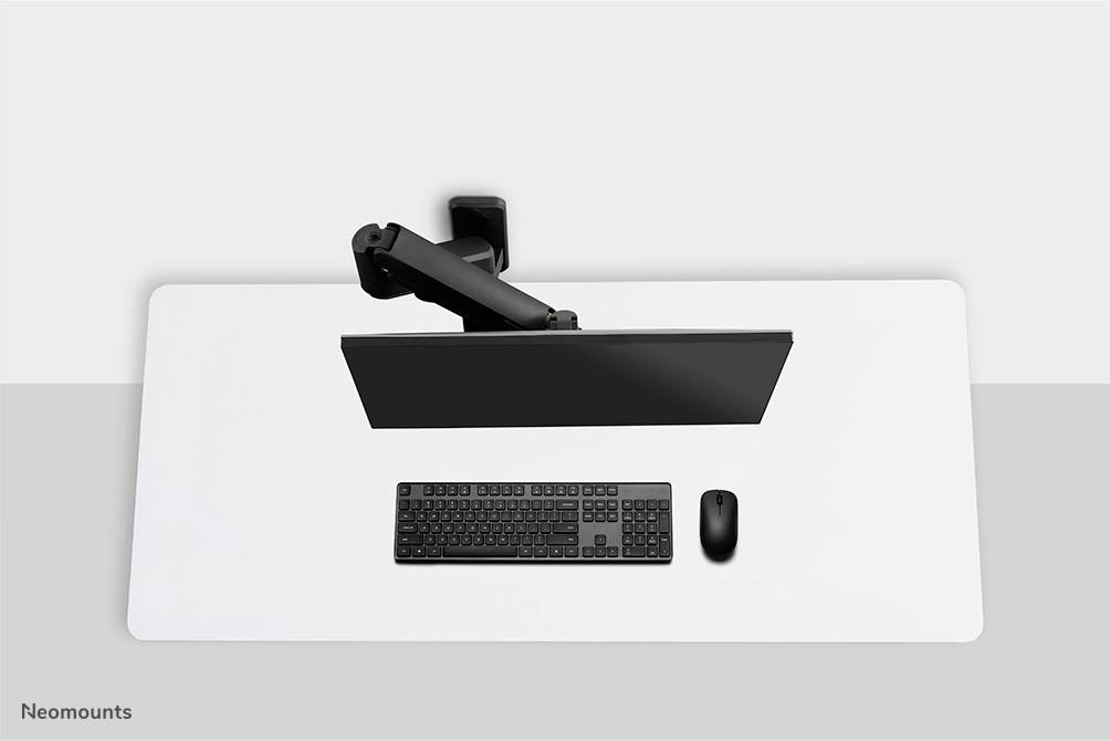 Ein Schreibtisch von oben: ein Monitor an einem Arm montiert, darunter eine Tastatur und eine Maus auf einer weißen Tischplatte.