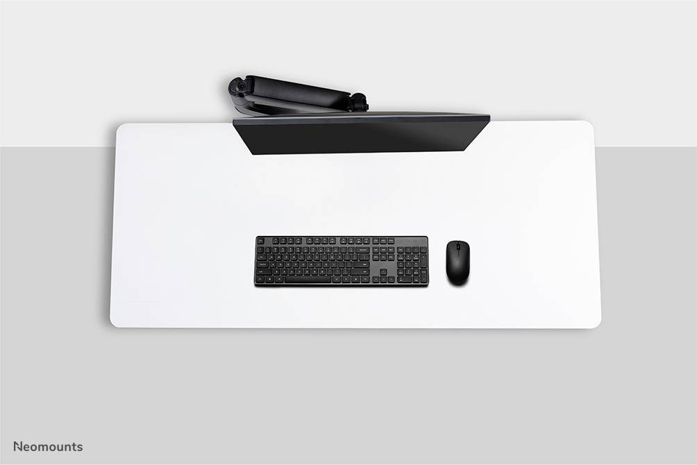 Schreibtischansicht von oben: Tastatur, Maus und Flachbildschirm auf weißem Tisch. Minimalistisches, geordnetes Setup.