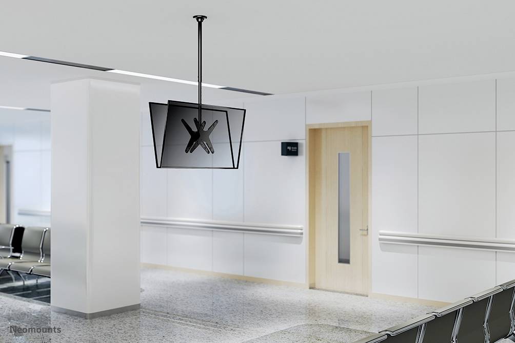 Ein leerer Wartebereich mit weißen Wänden und modernen Stühlen. Ein Flachbildschirm hängt von der Decke. Türen und Schilder sind sichtbar.