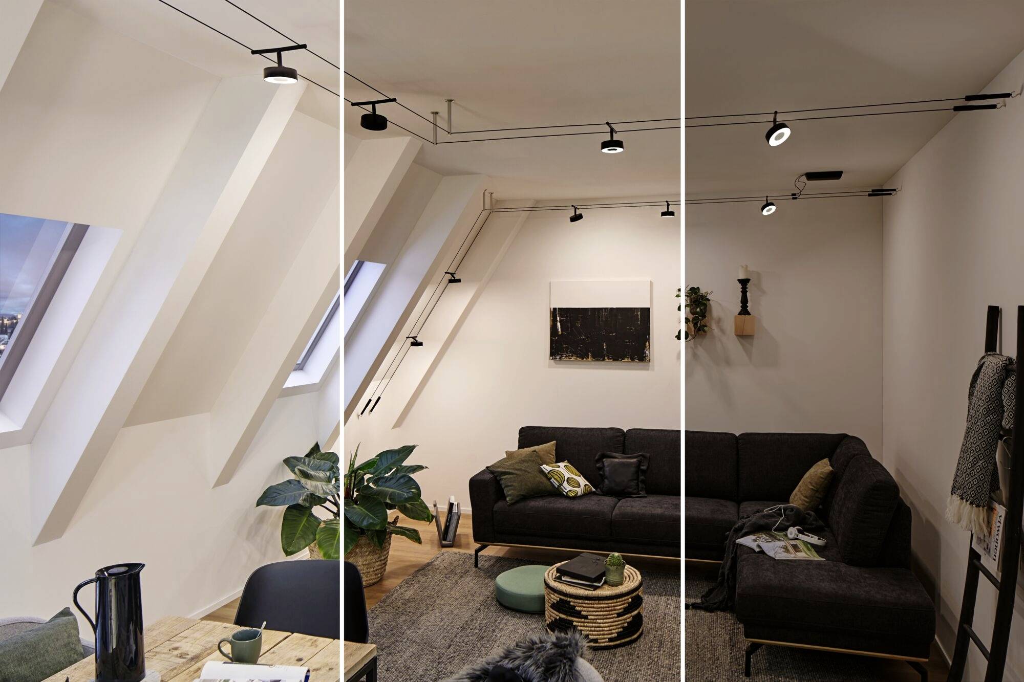 Helles Wohnzimmer mit schrägen Decken, einem großen Sofa, Pflanzen und moderner Beleuchtung. Ein Tisch mit Tassen steht links im Vordergrund.