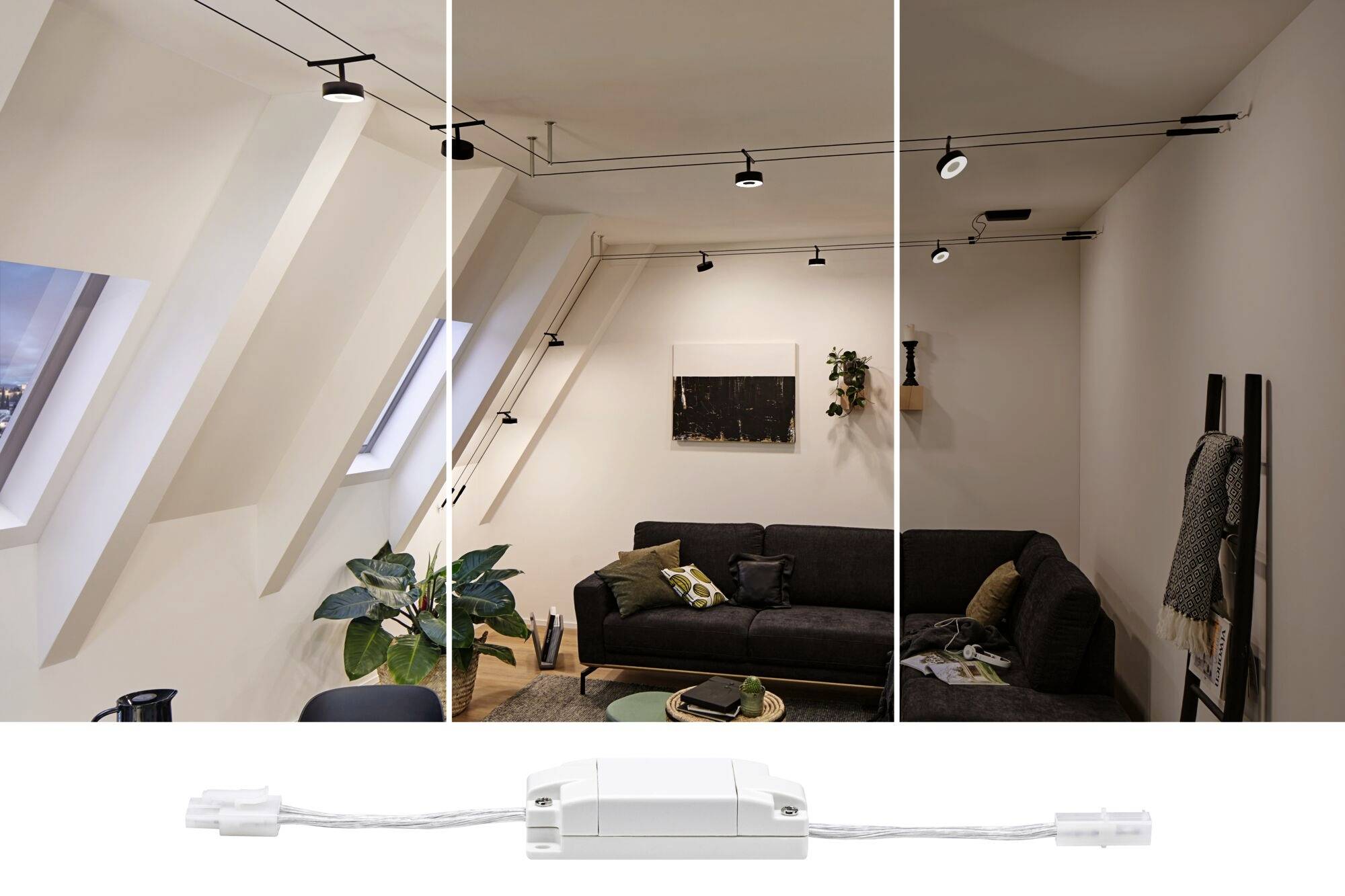 Wohnzimmer mit Sofa und Pflanzen unter schrägem Dachfenster. Mehrere Deckenleuchten beleuchten den Raum, darunter ein Steuergerät.