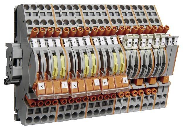 Mehrere elektrische Klemmenblöcke mit farbcodierten und beschrifteten Hebeln zur Verdrahtung von Schaltungen.