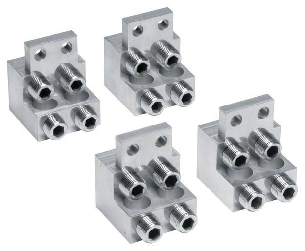 Vier quadratische Metallblöcke mit je zwei doppelten Steckverbindungen. Industrielles Verbindungselement aus silbernem Metall.