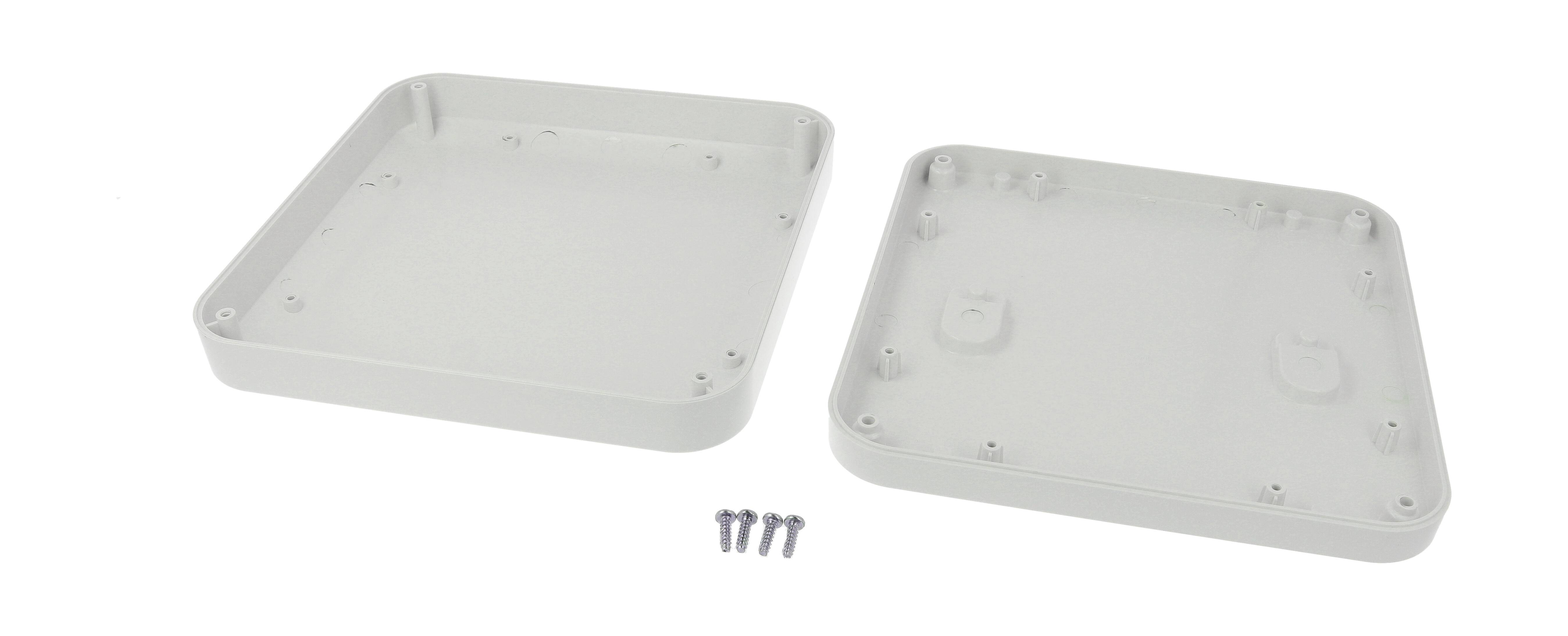 Zwei weiße, quadratische Kunststoffgehäusehälften mit abgerundeten Ecken, leicht auseinanderliegend. Drei kleine Schrauben davor.