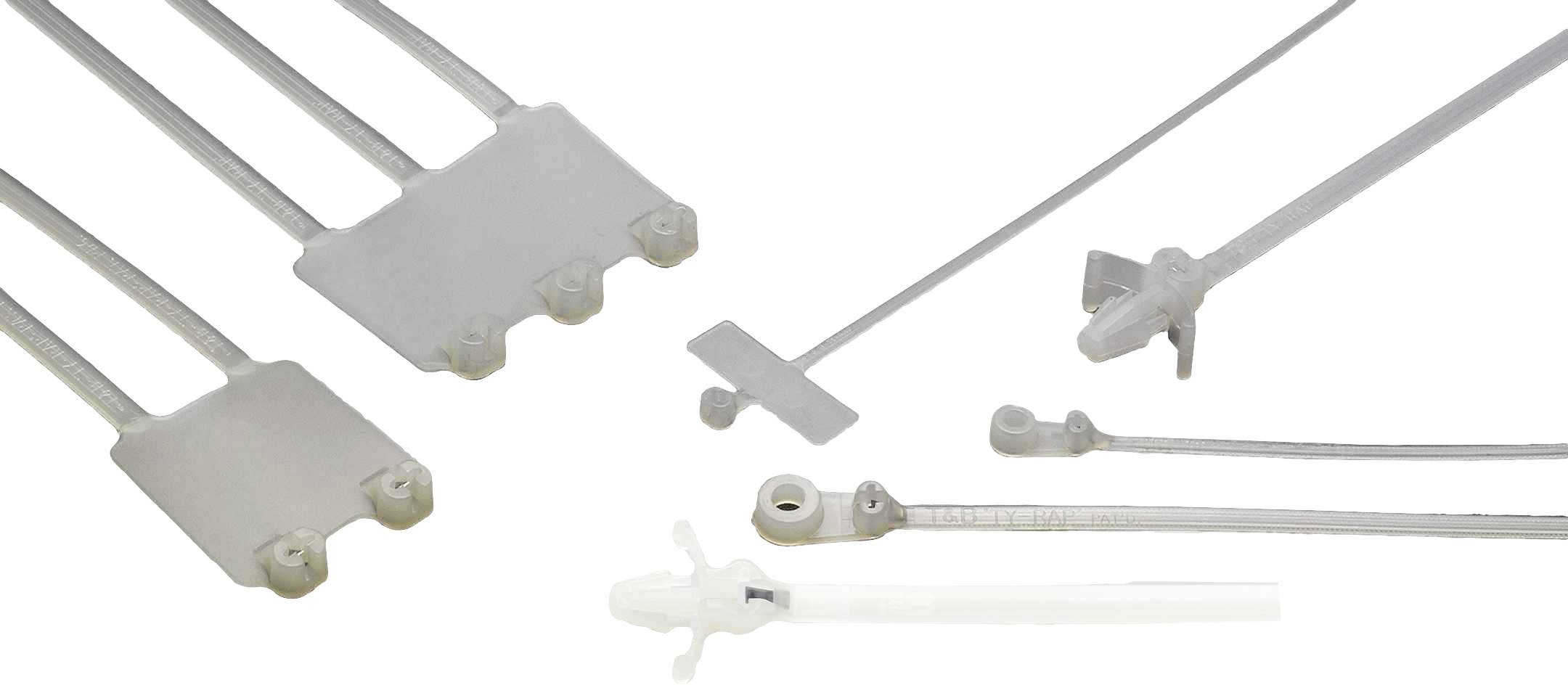 Graue Kunststoffteile und -formen, die präzise gefertigt sind, liegen auf weißem Hintergrund.