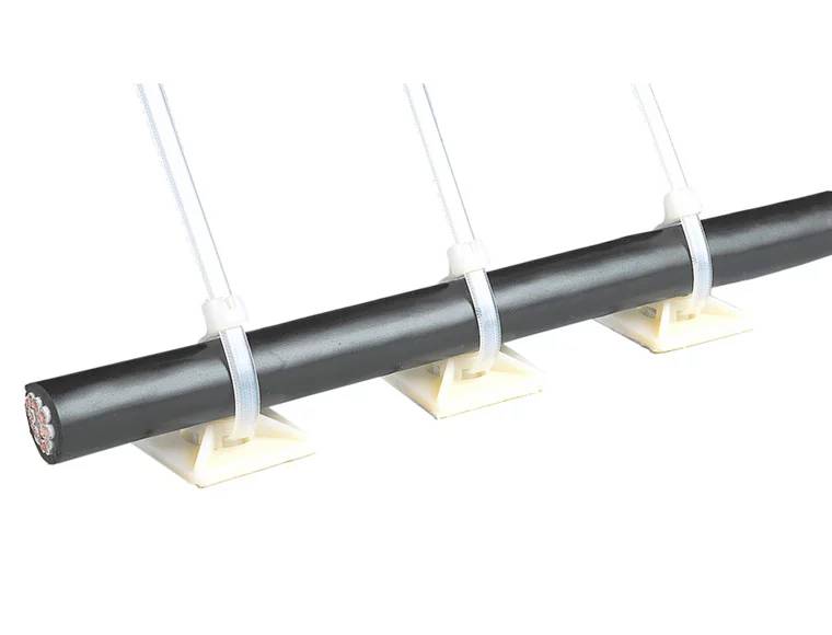 Isolierter schwarzer Zylinder, horizontal gehalten von drei weißen Halterungen mit Kabelbindern, auf weißen Sockeln montiert.